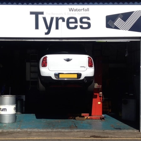 Tyre garage in Wimbledon with car on ramp in tyre bay